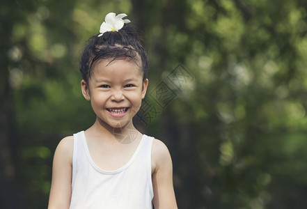自然快乐的小女孩黑冰雪白西装花在头上公园欢乐的笑容趣后代图片