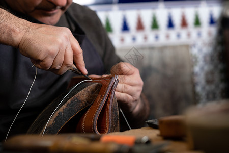 手工制作的艺匠用特别针头缝制皮革工人鞋匠高清图片素材