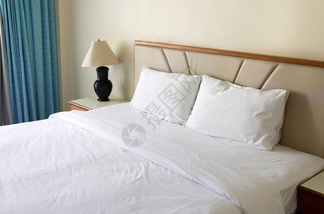 床头柜内部的带有枕头和桌灯的卧室内柔软图片