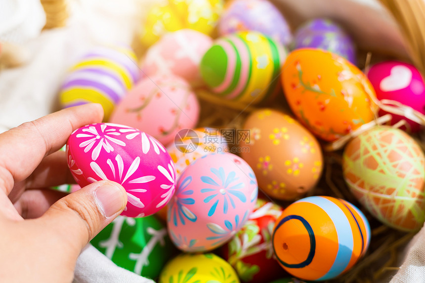 假期复活节概念近距离接在鸡蛋盒里拿着多彩的复活节蛋人白面纸上复活节鸡蛋带空间的锈木背景颜色头象征图片