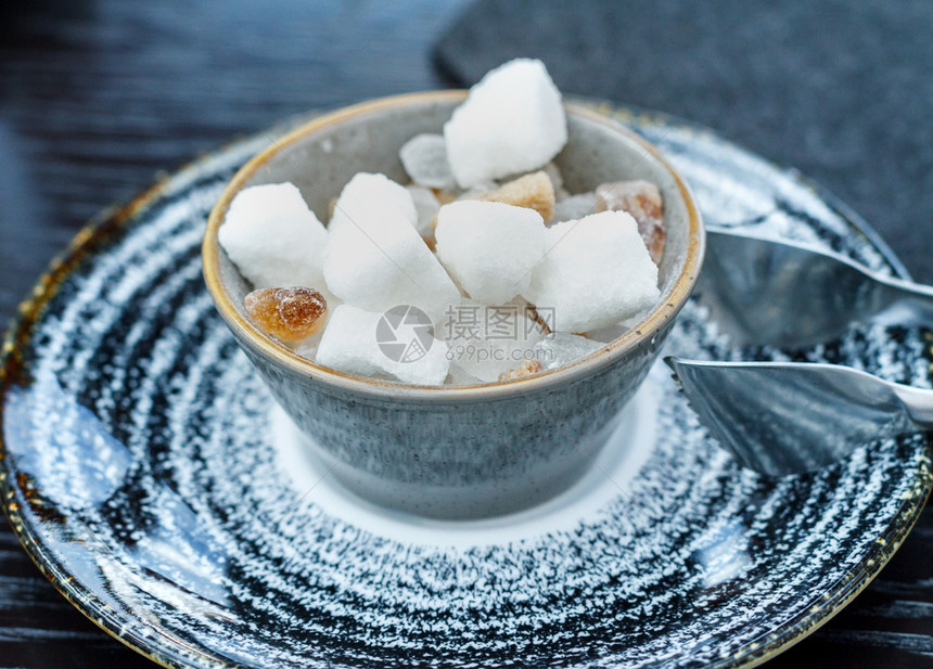 白糖和褐在木制桌上的杯子里加白糖和棕色的活力甜图片