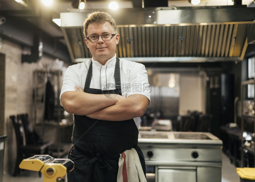男子厨师用手装着的表穿过厨房职业制服图片