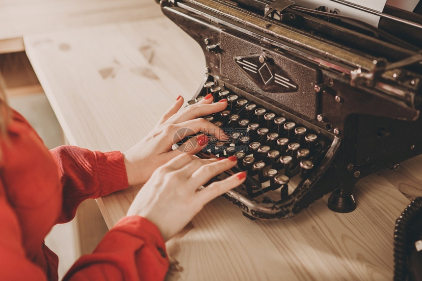 时尚使用打字机的年轻妇女商业概念Retro图片风格旧打字机秘书电话坐着工作图片