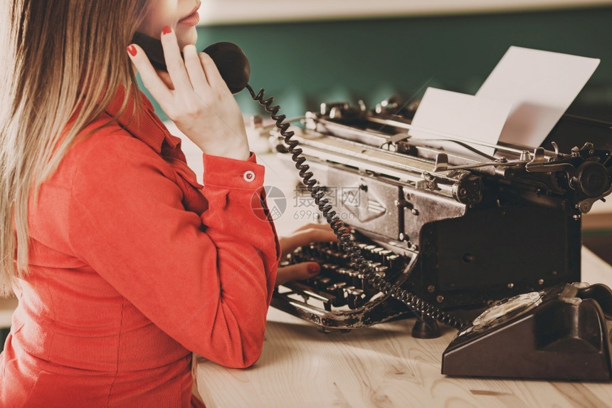 使用打字机的年轻妇女商业概念Retro图片风格旧打字机秘书电话桌子记者优质的图片