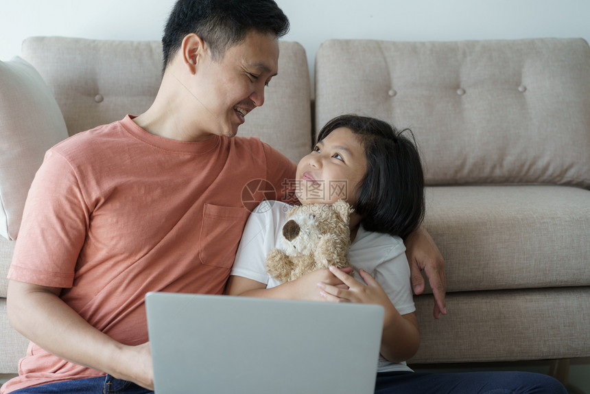 父母玩这个亚洲家庭有一父亲和女儿一个小孩和父亲使用笔记本电脑他们在家里很幸福中快乐拥有图片