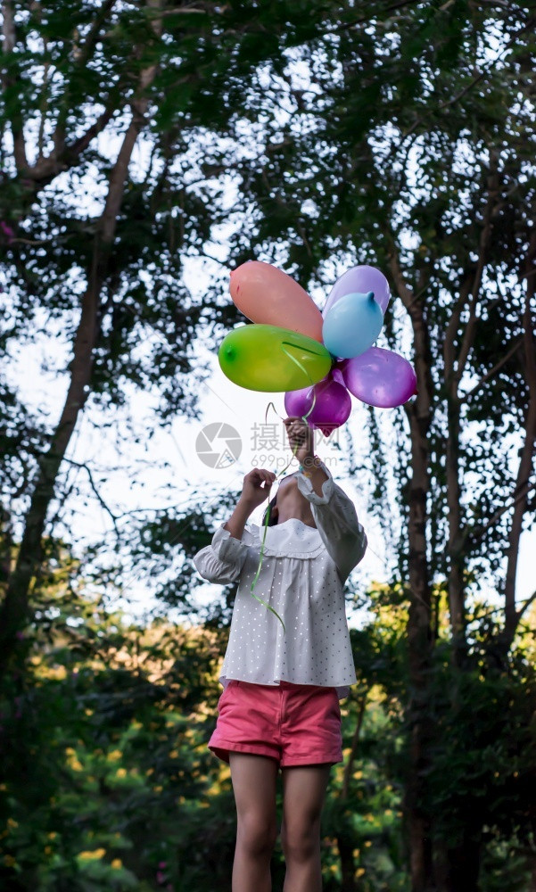 亚洲快乐女孩在公园户外露天玩多彩具气球手喜悦图片