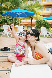 母亲和女儿在游泳池玩士咧嘴笑个人图片