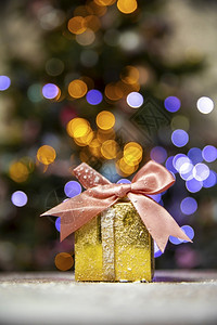 带粉红弓的黄金圣诞礼品有树布OK的灯光背景和影印空间假日带有粉色弓的黄金圣诞礼物目前Xma概念版面空间圣诞节树布基背景和影印空间背景