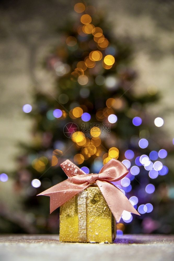 盒子闪亮的水平带粉红弓黄金圣诞礼品有树布OK的灯光背景和影印空间假日带有粉色弓的黄金圣诞礼物目前Xma概念版面空间圣诞节树布基背图片