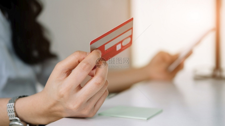 客户现代的女士使用信卡在移动电话网上购买和物时查封妇女的情况在手机上利用信卡进行采购和物图片
