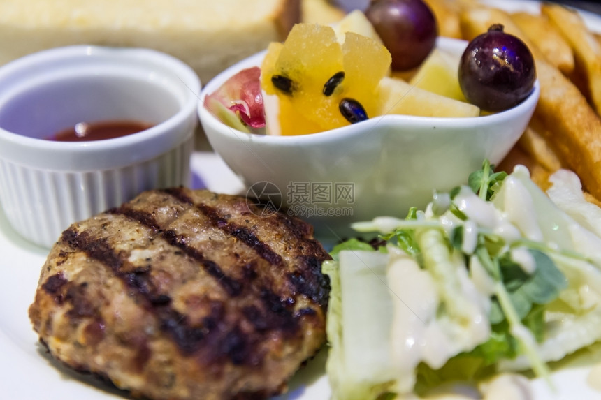 肉饼配汉堡包蔬菜和水果沙拉的晚餐地面自然图片