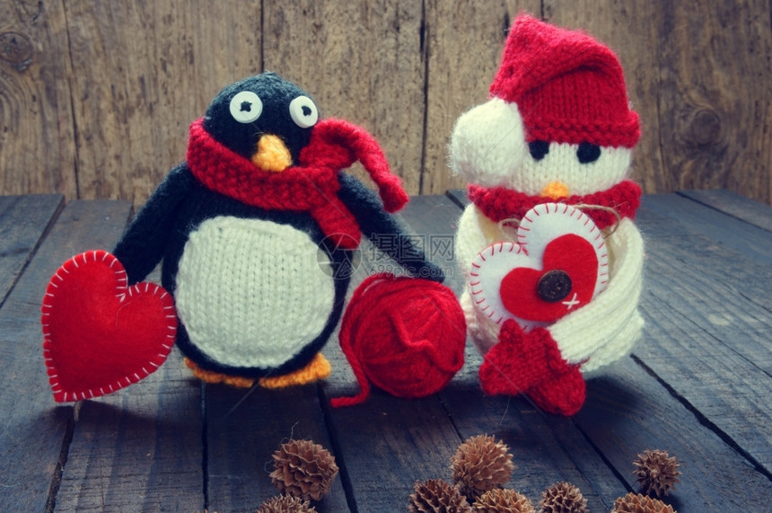 编织的Xma装饰品手工制雪人用红白羊毛做企鹅编织这是圣诞节日的玩具带有松锥果的抽象背景礼品卡红心锥体手工制作的松果图片