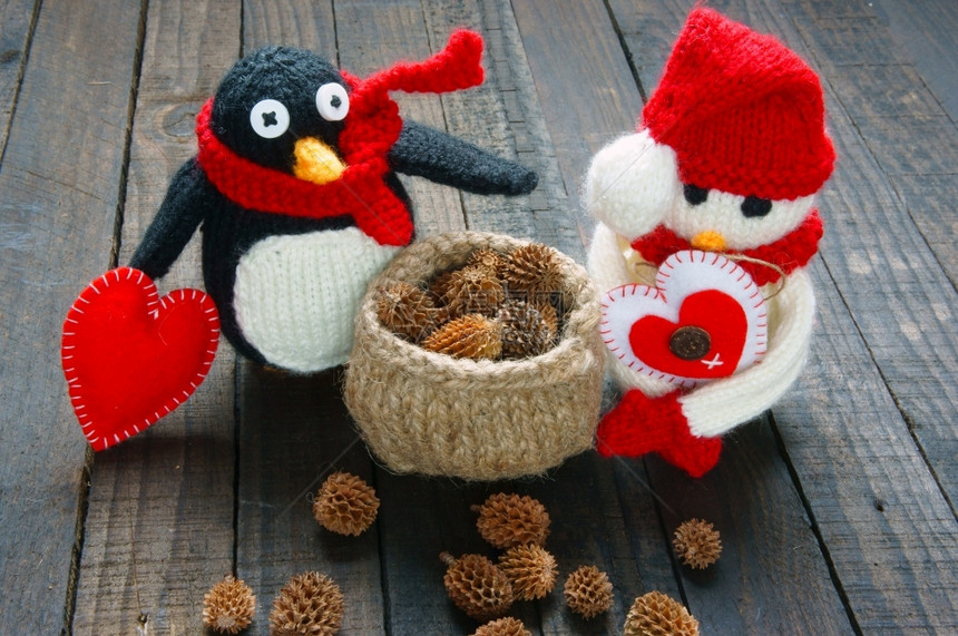 针织手工制作的棕色编织Xma装饰品手工制雪人用红白羊毛做企鹅编织这是圣诞节日的玩具带有松锥果的抽象背景礼品卡红心图片