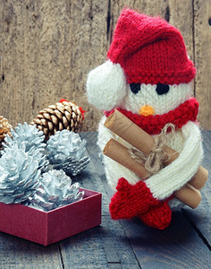 捧着礼物的雪人漂亮的编织Xma装饰品手工制雪人用红白羊毛做企鹅编织这是圣诞节日的玩具带有松锥果的抽象背景礼品卡红心寒冷的娱乐背景