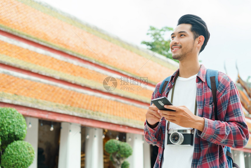 英俊的笏在泰国曼谷ThepwarararamRatchaworawihanSolo旅行和背包机概念上游街寻找智能手机旅游图片