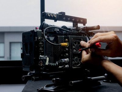 镜片技术员用螺丝起子换电影摄机的冷却风扇数字图片