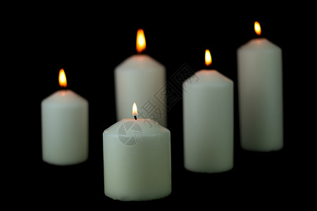 烛光美丽的祈祷5支光火蜡烛在黑色背景上闪亮燃烧图片