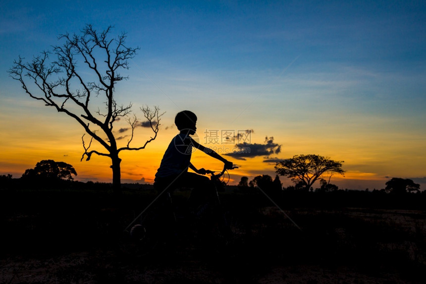 骑自行车的人日落天空背景的山上小车圆月光活动阴影图片