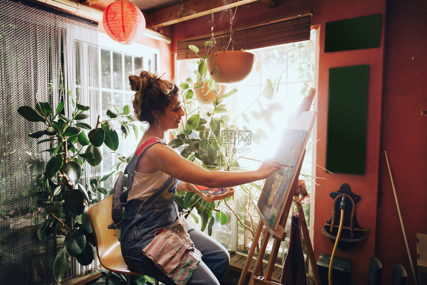 创造力框架画廊与工厂一起在作室的画布上拍摄专业女艺术家绘画的室内镜头