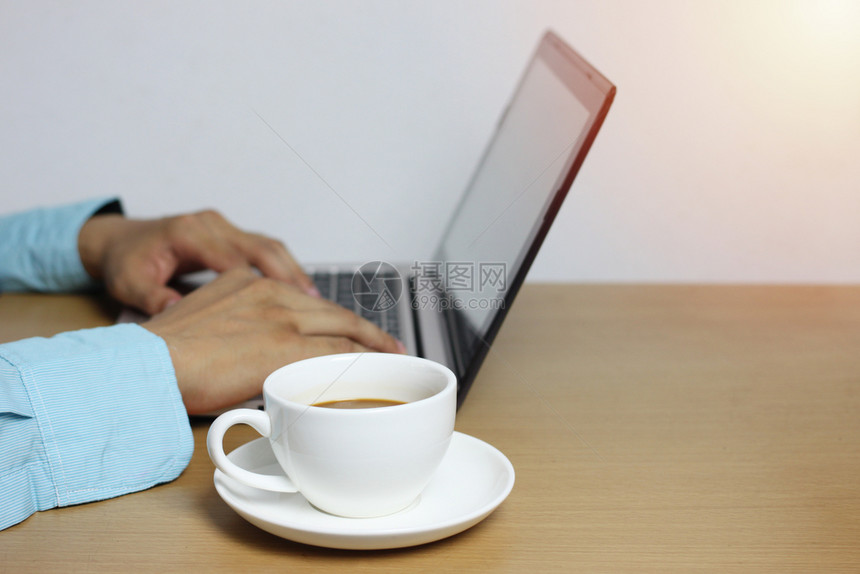 工作区早餐公司的棕色木地板上的白咖啡杯和键盘上商人Hand的电脑笔记本并有复制空间输入你的工作想法图片