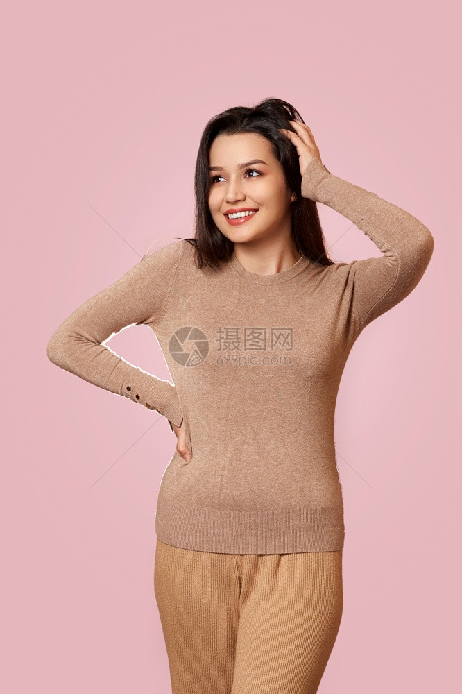情感可爱的亚洲人一个年轻美丽的黑发女孩穿着浅褐色外套在粉红孤立的背景下笑图片