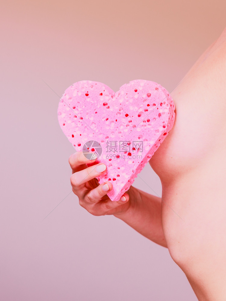 光露妇女其美丽的身材完皮肤将粉红色的心形海绵握在手掌中赤身妇女将粉色的心状海绵握在手中光滑的身体感图片