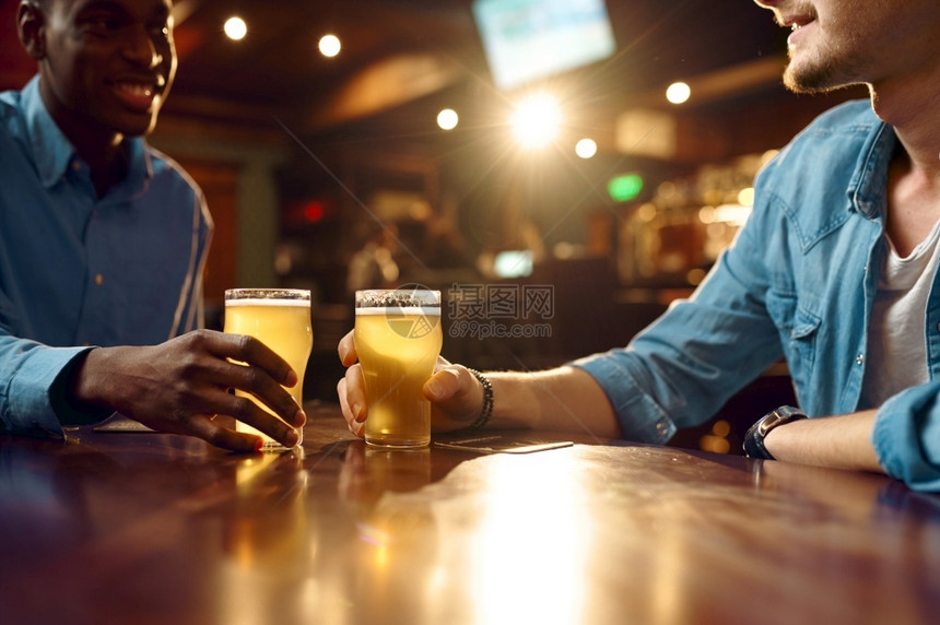 室内的快乐两个男朋友在酒吧喝新鲜啤人们在吧放松夜间生活方式友谊动庆祝男人在餐厅休闲两个男朋友在酒吧喝新鲜啤夜店图片