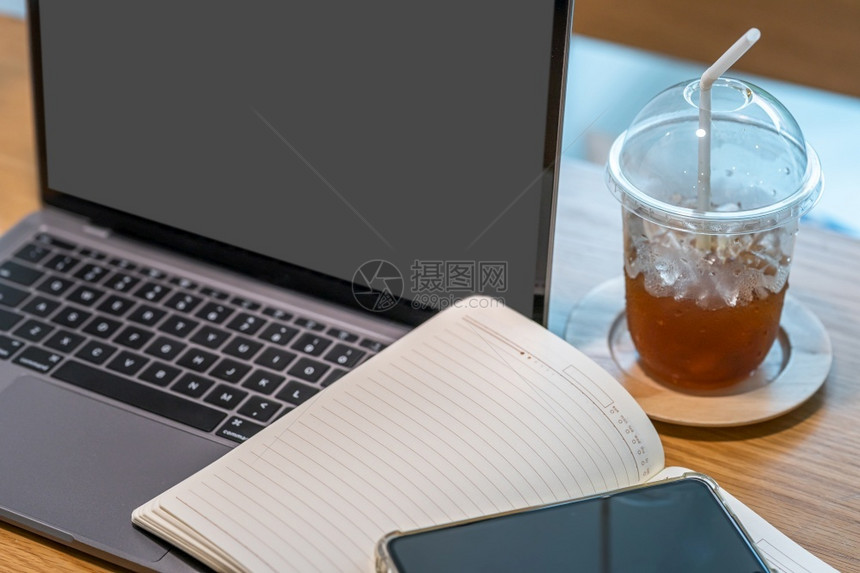 在商业工作构想期间关闭咖啡厅木制办公桌上的键盘膝型计算机笔记本智能手和咖啡杯休息早晨笔记本电脑图片