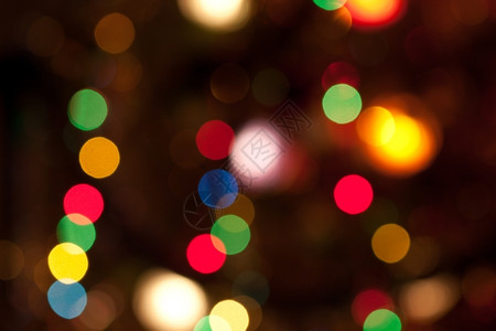 闪耀明亮的彩色圣诞光灯抽象背景黑色的季节模糊图片