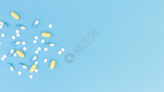 蓝色背景上的药片和胶囊图片