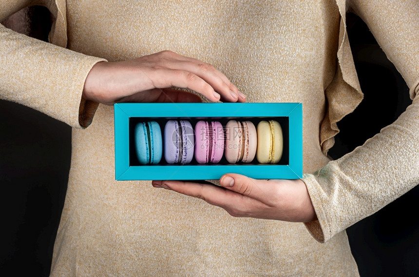 奶油法语糕点女手握着彩色多马卡龙装在礼品盒中女手握着红心松装在盒子中图片
