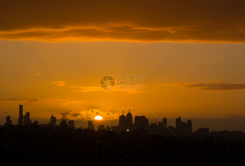 天空外部的墨尔本市天际之后的金色大太阳落下市中心图片