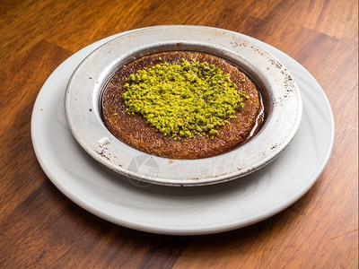 糖传统土耳其甜点Kunefe服务于Pistachio美味的晚餐图片