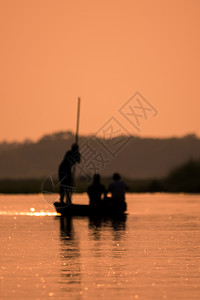 寂寞钓鱼一条船上的模糊男子在河边的光影中闪烁着日艺术模糊太阳图片