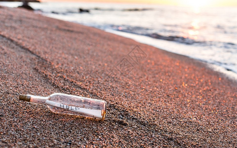 股地平线目的水瓶里有信息在海滩岸边的图片