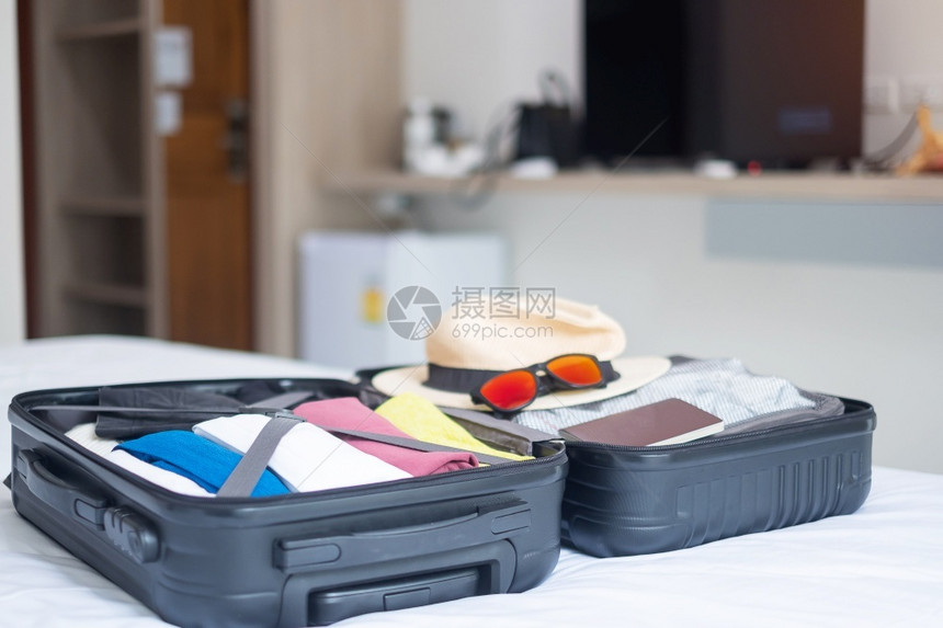 床上行李箱中暑假旅配件的李放松和周末概念的时间查看旅游准备图片