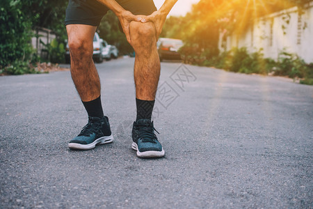 肌肉男子在慢跑时膝部疼痛身体的跑步图片