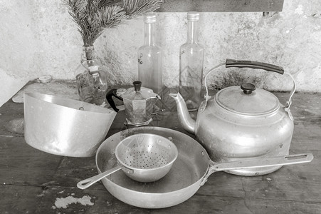 工具一种墙餐桌上的旧物品厨房锅筛子水壶咖啡和三瓶图片