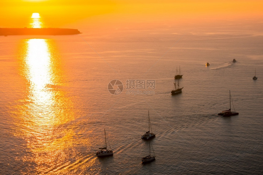 双体船游艇和迦太马人与游客一起乘着海日落和帆游艇在海面上行驶阳光天空图片