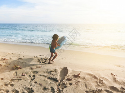 小男孩正在快乐的奔向大海奔跑图片