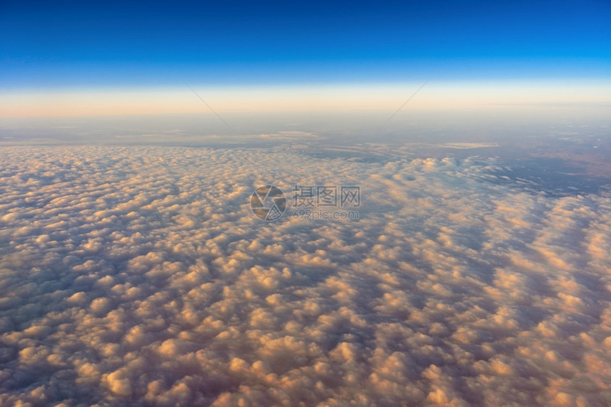 金的在日出交通和旅行者构想时从飞机侧窗对面的视线上向外倾望天空的金云多于运输图片