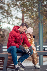 乐趣家庭冬季运动在溜冰场滑家庭冬季运动父亲和女儿在冬日父母爸图片