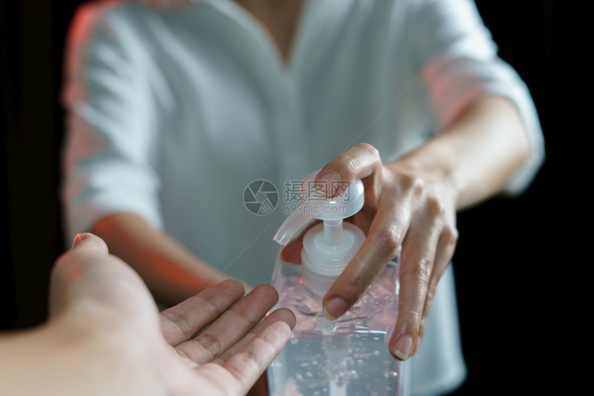 妇女共用酒精凝胶或清洁剂用于洗手冠状或Covid19保护杀防止消毒图片