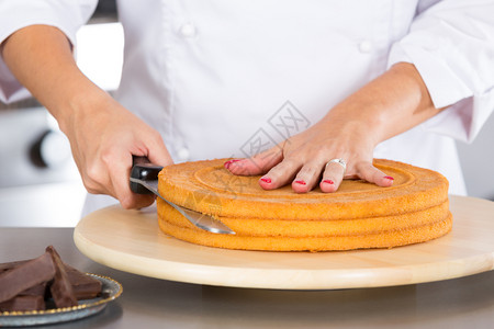 手厨房的糕点师装饰巧克力蛋糕盘子专业的图片