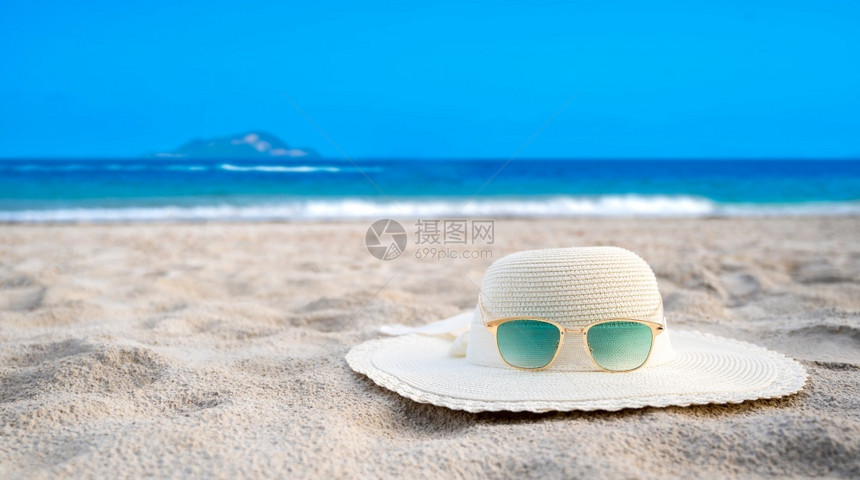 帽子和眼镜在晴朗的一天放海蓝滩上热带娱乐旅游图片
