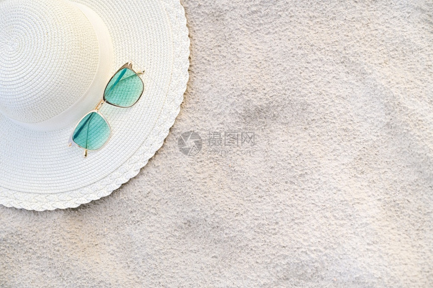 帽子和眼镜在晴朗的一天放海蓝滩上天空旅行桌子图片