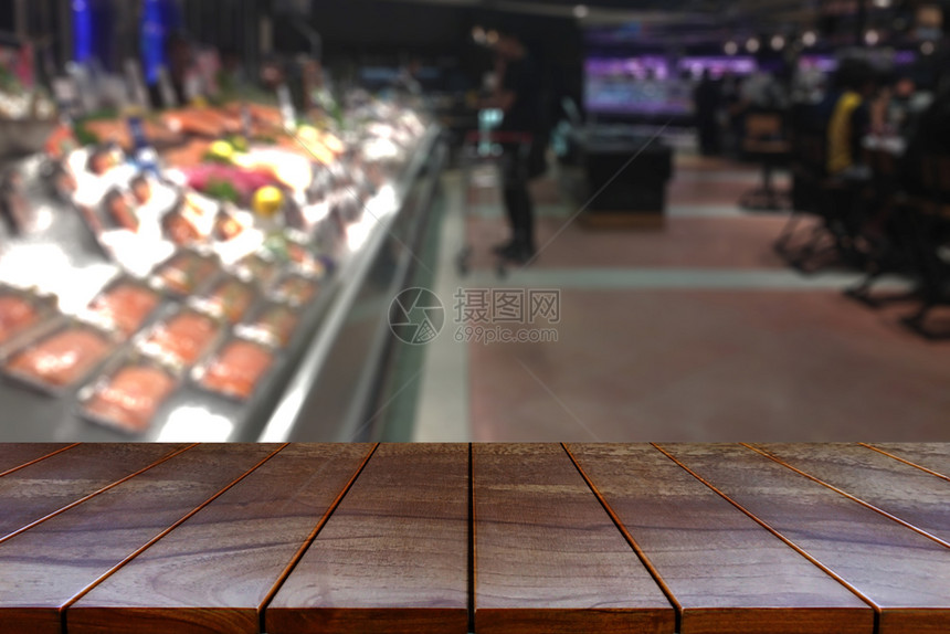木头消费者店铺空木板桌间平台和模糊的超市过道产品展出时有架背景显示设备图片