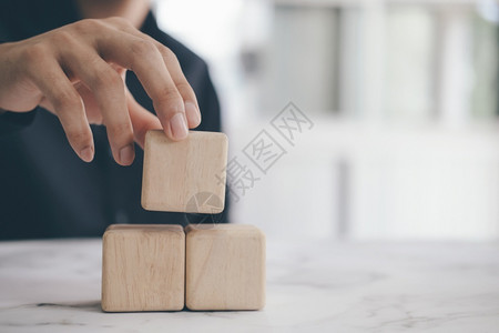 形成在金字塔顶端持有空白木立方块的手生长最佳图片