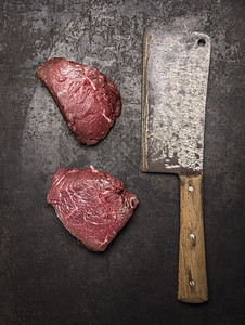 里脊肉稀有的两块新鲜生牛肉排和刀在深黑的生锈背景最美迷迭香图片
