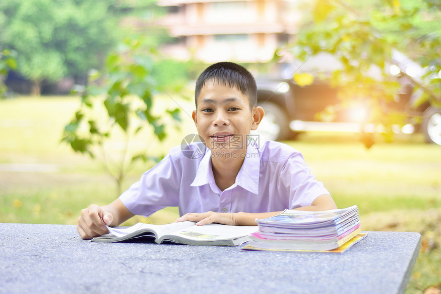 教育学习亚裔男孩在学校早上的桌看书他先学科数和然后才进行实验以及夏天亚洲人图书图片